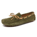 Men’s penny loafers in stylish green suede, adorned with a tan bow and detailed stitching.