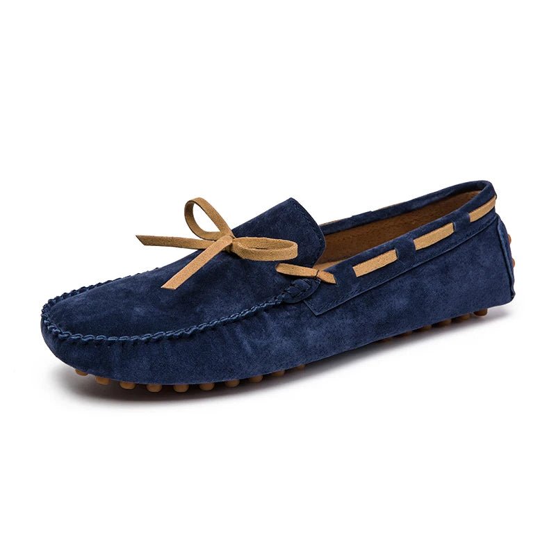 Men’s penny loafers in stylish navy suede, adorned with a tan bow, showcasing elegance and comfort.