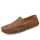 Brown suede slip-on men’s loafers with visible stitching and a flat sole, against a plain backdrop