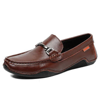 Casual men’s loafers in brown leather with a metal buckle, black rubber sole, and an orange side label.