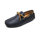 Stylish men’s driving shoe in dark blue leather with yellow lace and tan interior, displayed on a white background.
