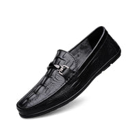 Men’s leather loafers, black, with a textured pattern and a metal ornament on the top, viewed from the side.