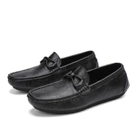 Stylish Men’s loafers’ shoes in black textured leather with elegant bow detail, showcased on a white background.