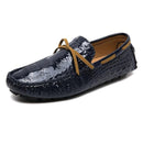 Men’s slip-on loafers in glossy dark blue with textured surface, adorned with tan laces, on a white background