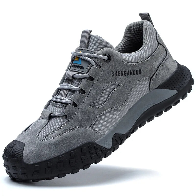 Grey SHENGANDUN steel toe shoe with black soles, showcasing its rugged design for safety and durability